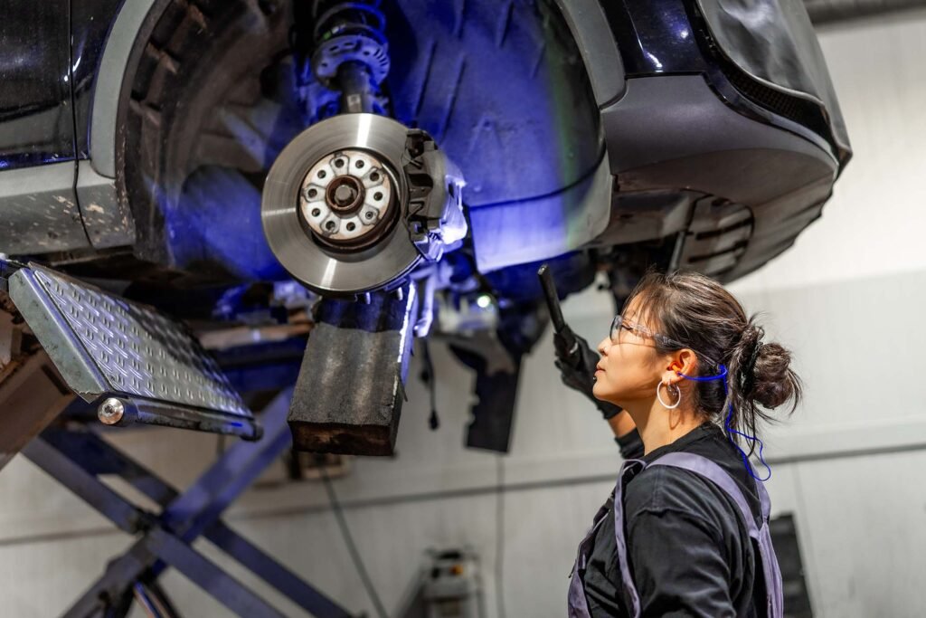 female-mechanic-inspecting-car-brakes-in-auto-repa-9N6W69T.jpg